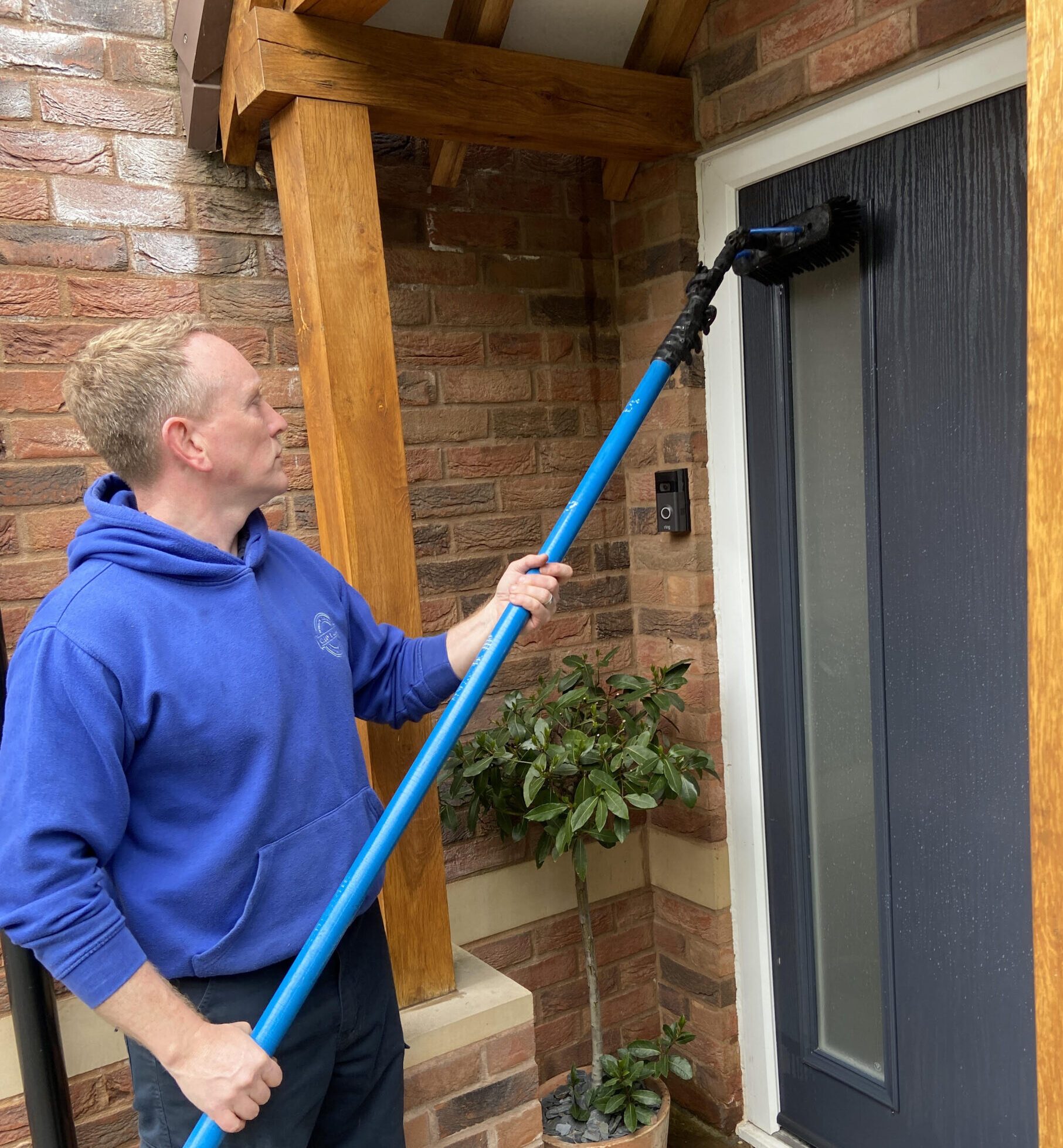 Professional window cleaner efficiently cleaning a ground floor window